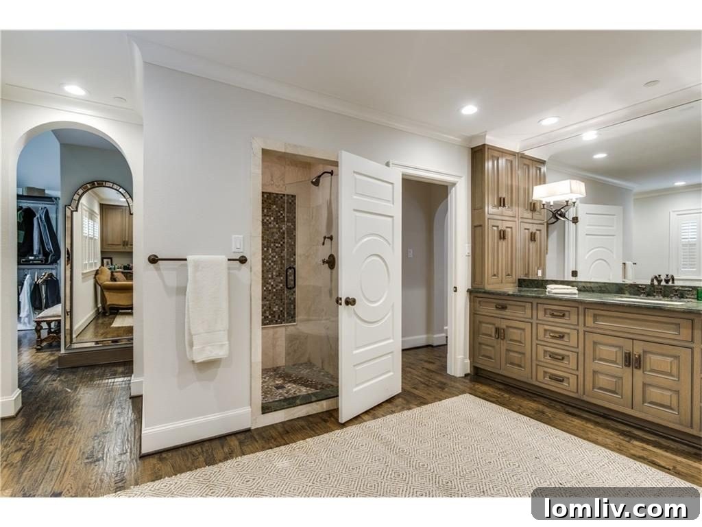 Master bathroom suite with dual vanities, large mirrors, and direct access to walk-in closets