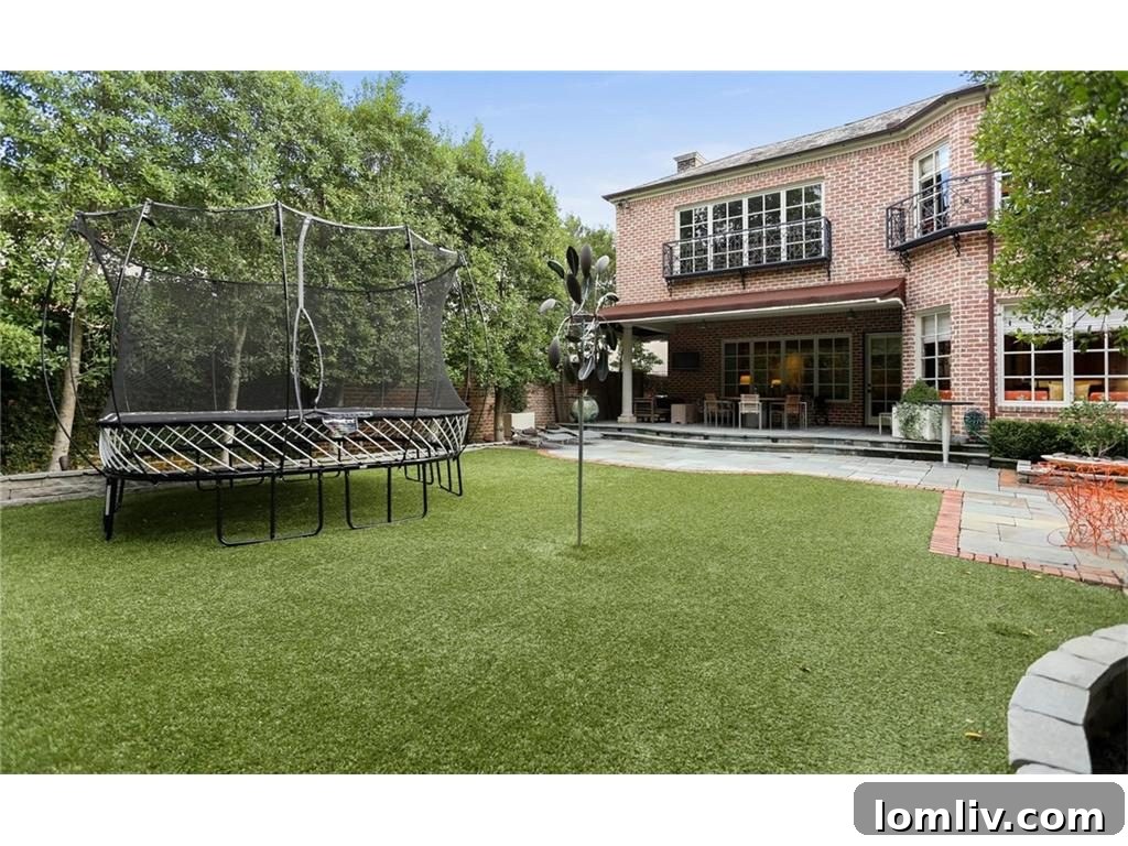 Elegant rear exterior of the Highland Park custom home with manicured landscaping