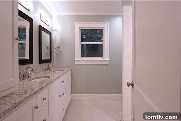 Luxurious master bathroom vanity with contrasting mirrors and elegant sage walls.
