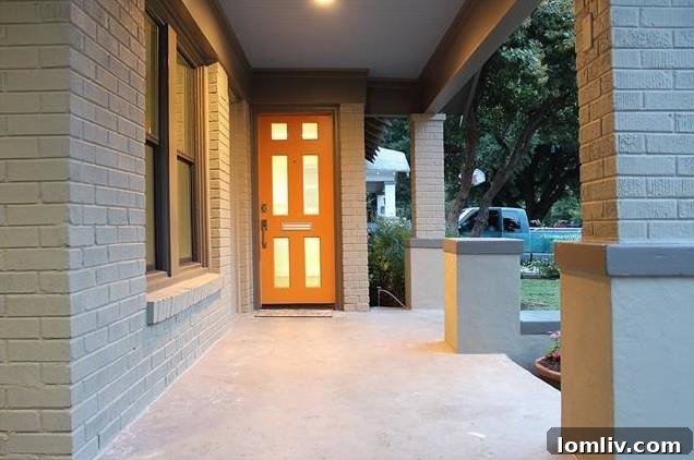 Inviting front porch of 1122 Brunner, showcasing new landscaping, fresh paint, and a striking front door.