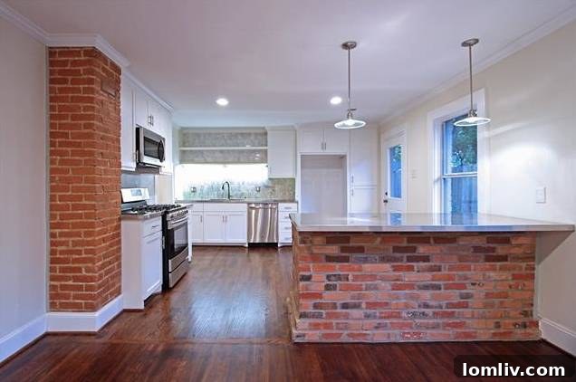 Close-up of the fully renovated kitchen, showcasing stainless steel appliances and subway tile backsplash.