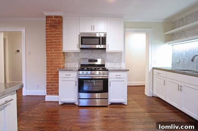 Another perspective of the kitchen, highlighting the ample white Shaker-style cabinetry.