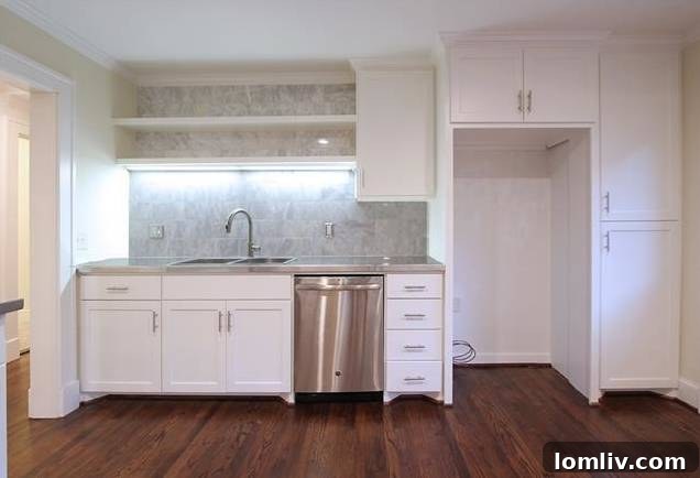 Kitchen view showing the modern drop-in sink and stainless steel countertops.