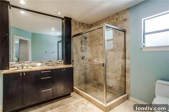 5220 Parkland Avenue: Modern master bathroom with glassed shower and large mirror