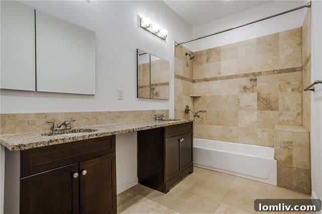 5218 Denton Drive: Renovated master bathroom with double sinks and travertine