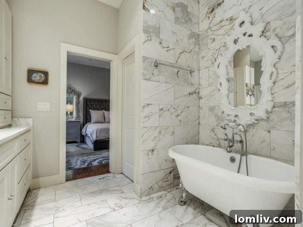 A pristine Jack-and-Jill bathroom, showcasing the same elegant Calcutta marble used in the master suite, offering sophisticated design for shared spaces.