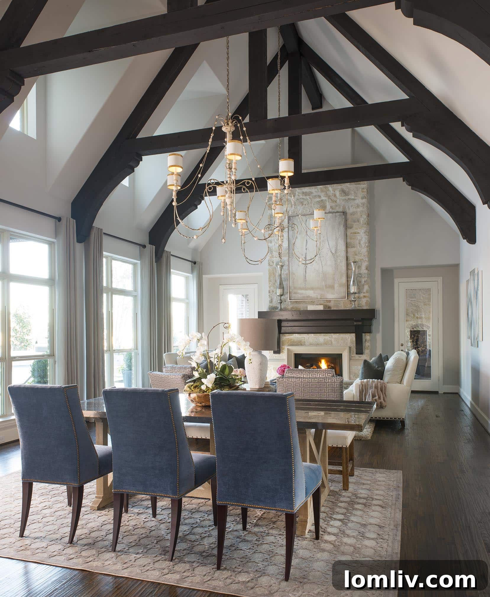 Open-concept dining area and family room with dark wood ceiling beams
