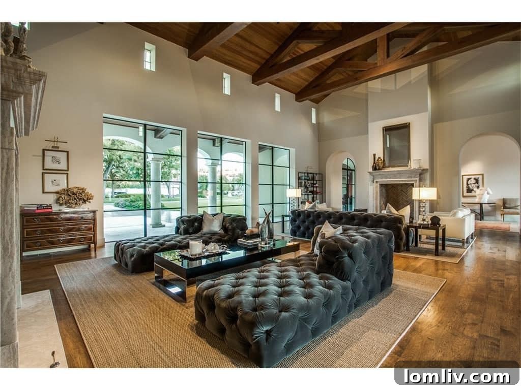 Overview of the grand living room, highlighting the connection to outdoor loggias through massive glass doors
