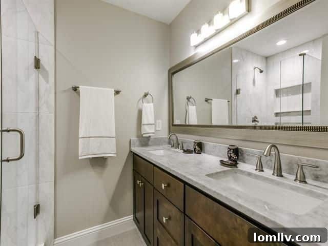 Elegantly renovated master bathroom with large shower, shaker vanity, and stone countertop