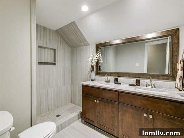 Second bathroom featuring dual sinks, shaker cabinetry, and stone finishes, with a unique shower setup