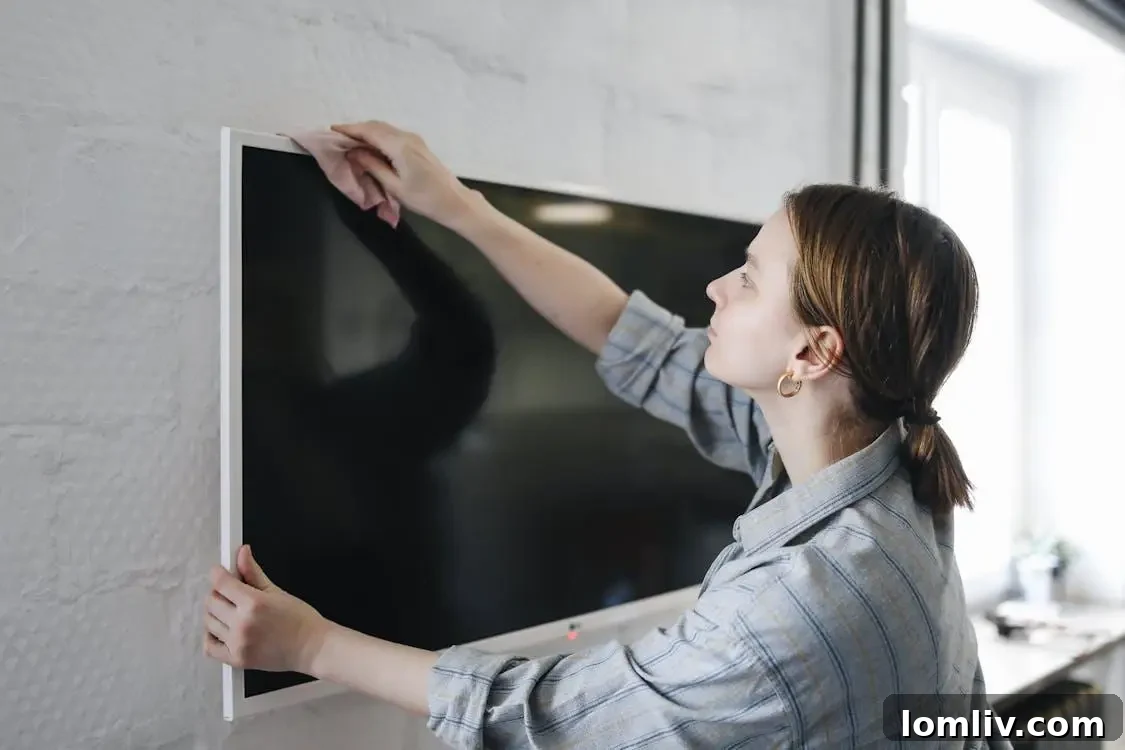 A woman wiping a television with a cloth, symbolizing thorough cleaning