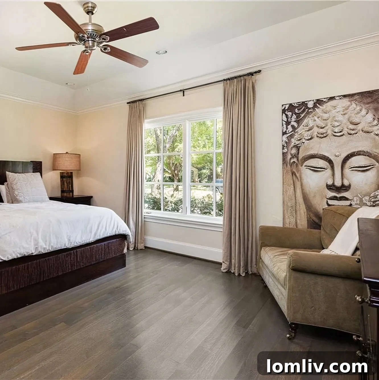 Master bedroom with a peaceful Buddha head artwork and a comfortable armchair